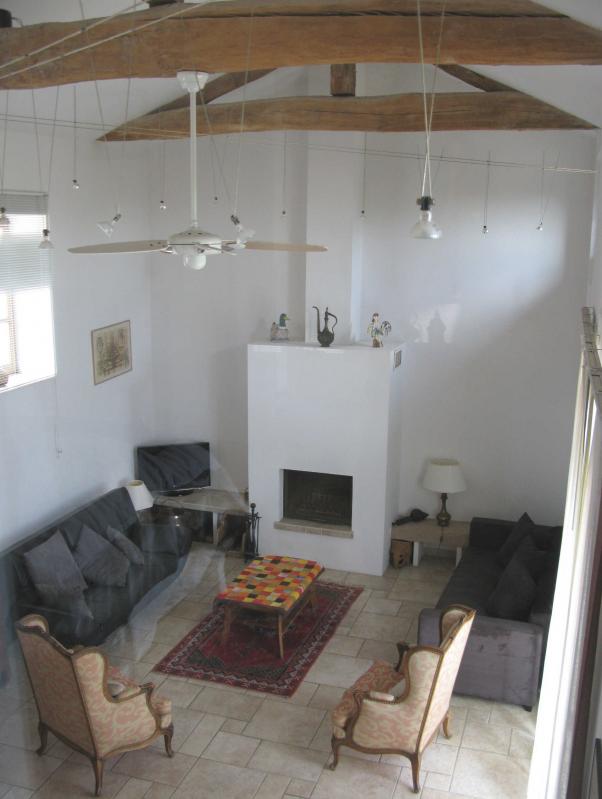 Vue du salon vers la cuisine et l'entr&eacute;e, avec l'ouverture sur la chambre en-haut